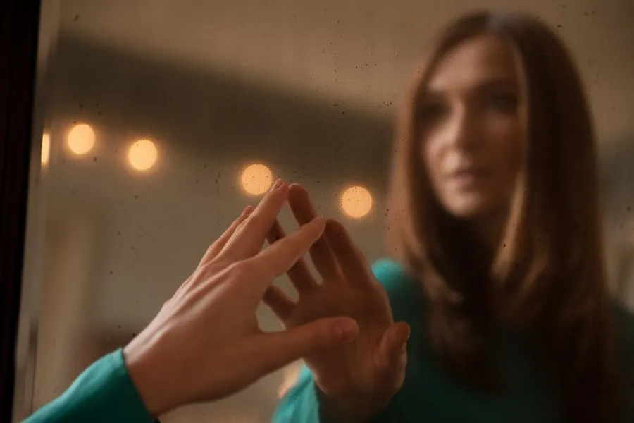 woman touching a mirror